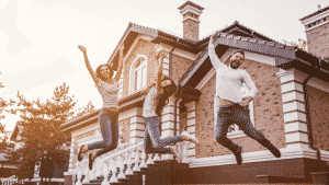 Happy family jumping in front of their house